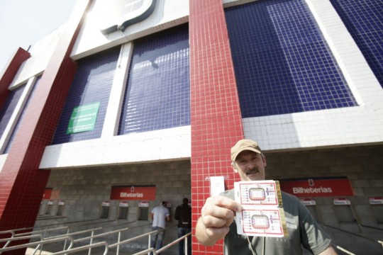 Torcedor mostra com orgulho os ingressos comprados