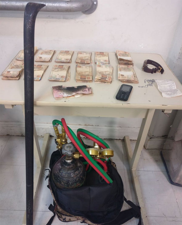 Com o trio, os policiais apreenderam R$ 12 mil, que tinham sido retirados do caixa eletrônico cortado. Foto: Divulgação/PM.