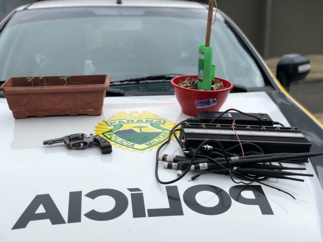 Revólver, bloqueador de sinal celular e pés de maconha apreendidos pela polícia. Foto: Divulgação/PMPR