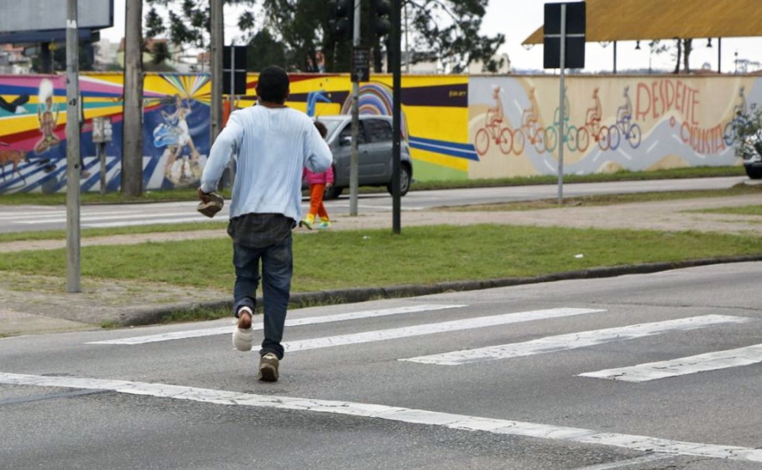 Rapaz recebeu atendimento e saiu apressadamente pulando atrás do busão. Foto: Átila Alberti.