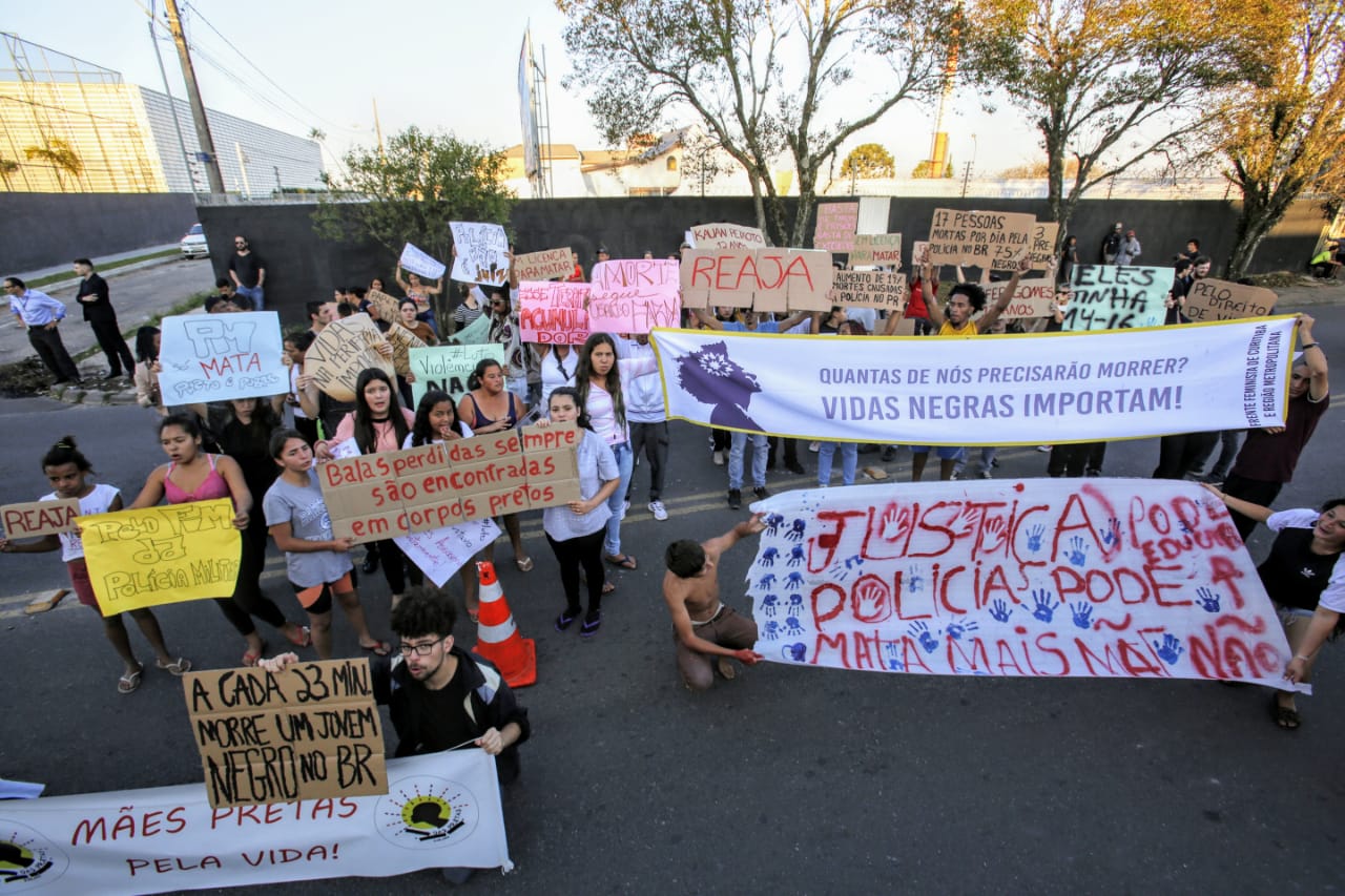 Participantes carregam cartazes e pedem investigação das mortes. Foto: Atila Alberti/Tribuna do Paraná.
