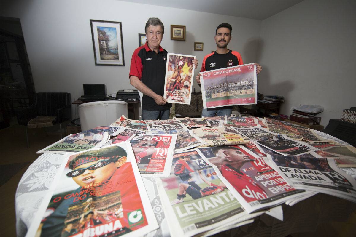 Pai e filho carregam os jornais da Tribuna com as conquistas do Brasileiro de 2001 e da Copa do Brasil de 2019. Foto: Lineu Filho. 