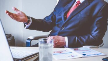 Imagem mostra um chefe em uma mesa de trabalho dando uma lição em um subordinado. O assunto é tema das piadas do Darta