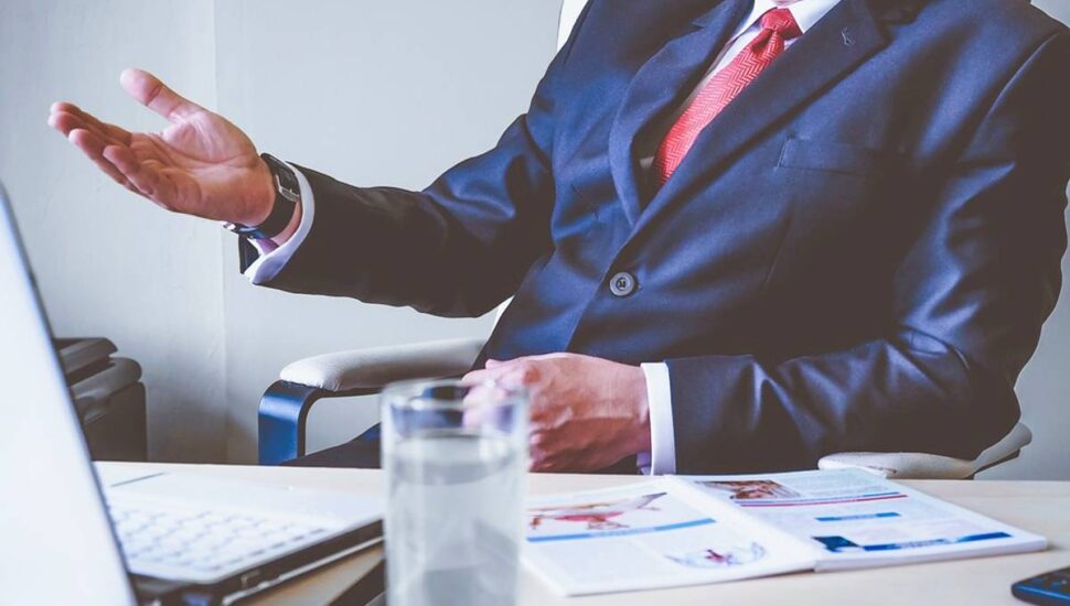 Imagem mostra um chefe em uma mesa de trabalho dando uma lição em um subordinado. O assunto é tema das piadas do Darta