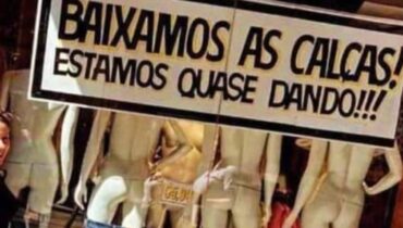 Imagem mostra uma promoção com queda de preço em uma loja que diz o seguinte: baixamos as calças, estamos quase dando.