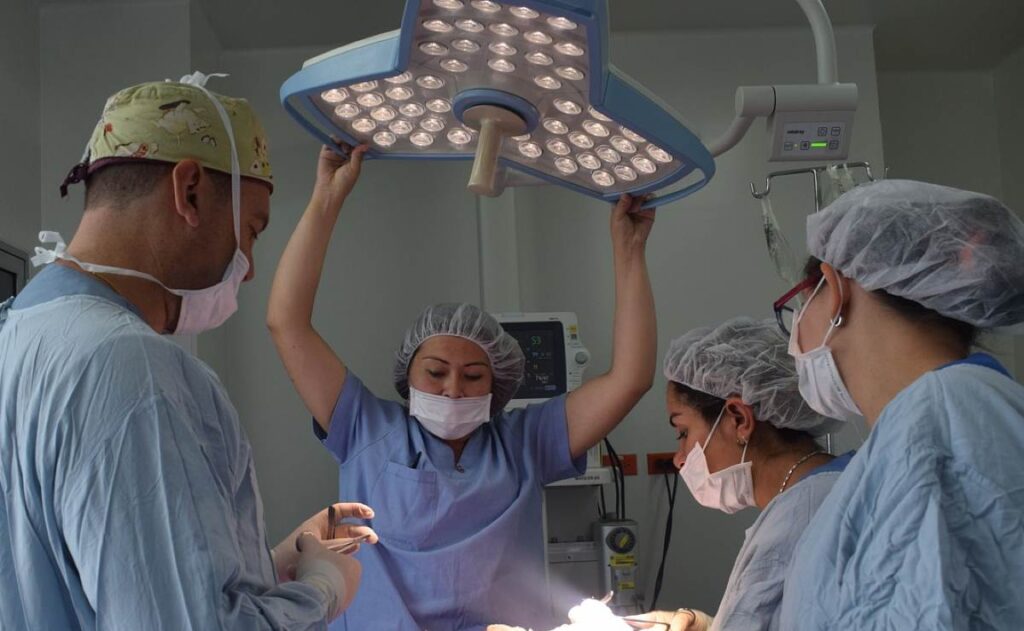 Cirurgião plástico faz uma cirurgia de implante de silicone em um centro cirúrgico