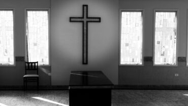 capela mortuária em preto e branco com uma cruz ao fundo