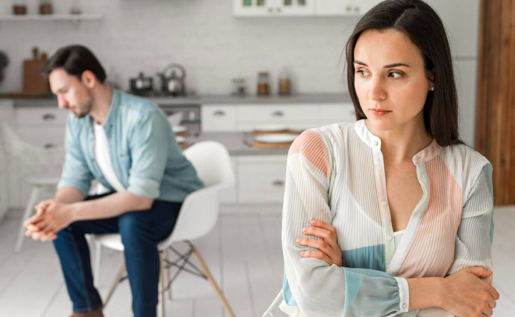 Imagem mostra um homem e uma mulher em uma cozinha. Eles estão com cara de choro.