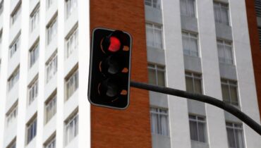Imagem mostra um sinaleiro vermelho em Curitiba