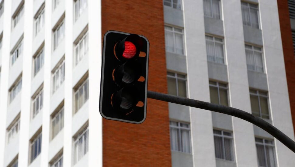 Imagem mostra um sinaleiro vermelho em Curitiba
