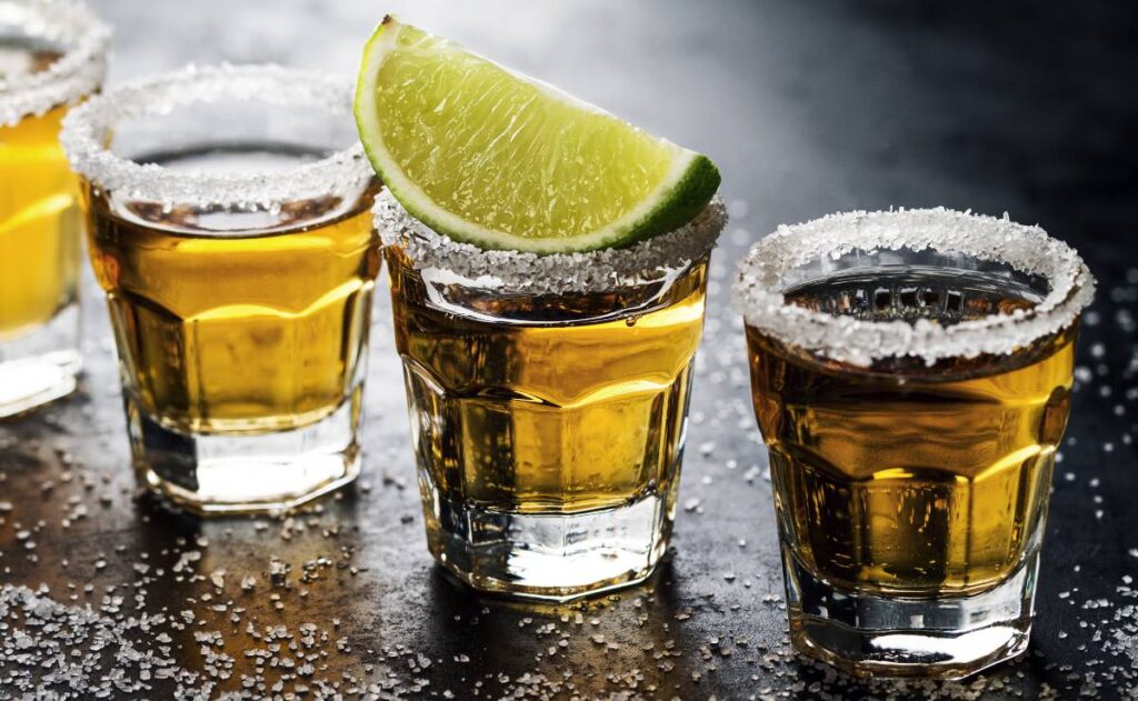 Imagem mostra copinhos com doses de tequila com limão e sal