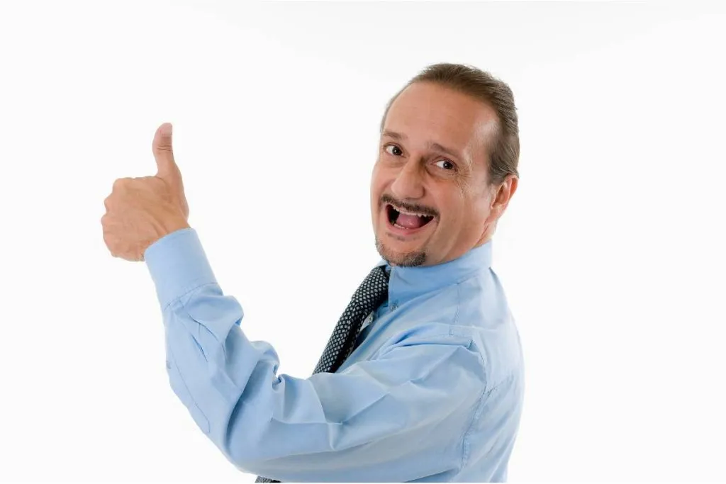 Imagem mostra um homem de terno fazendo joinha para a foto