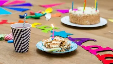 Imagem mostra um bolo de aniversário servido em um pratinho.