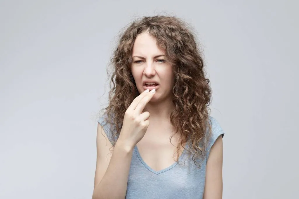 Imagem mostra uma jovem com cara de nojo