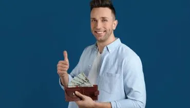 Imagem mostra um homem feliz fazendo joinha e com a carteira cheia.