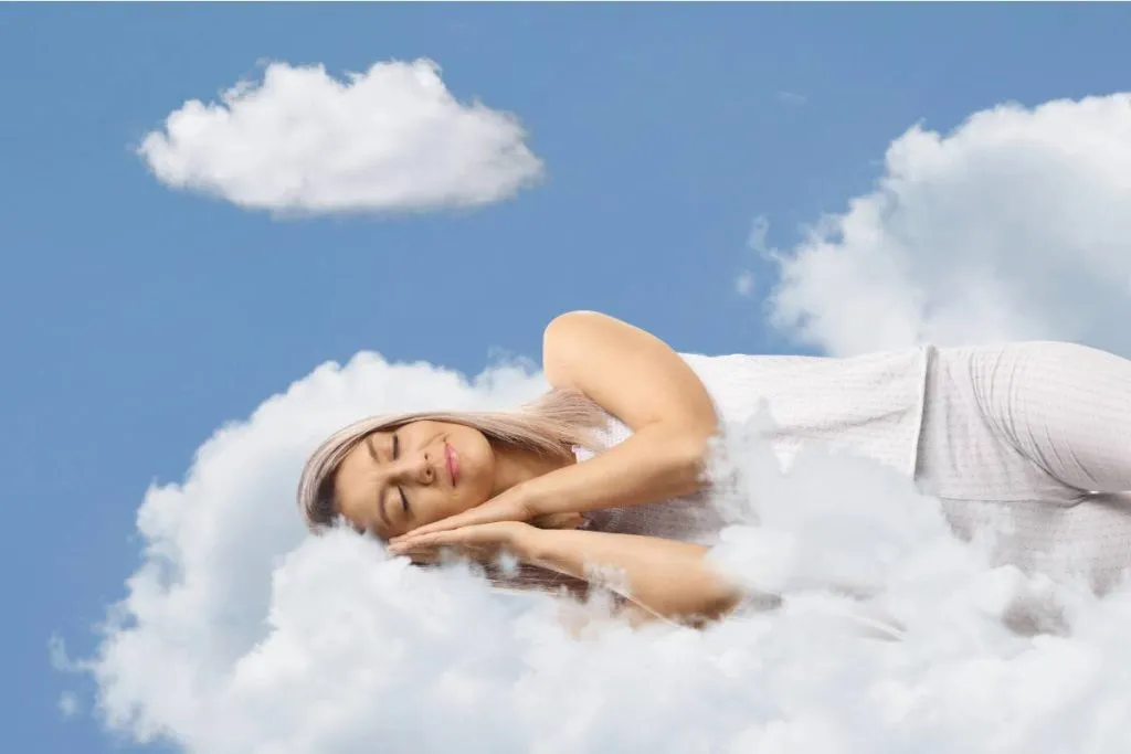 Imagem mostra uma mulher deitada em uma nuvem sonhando