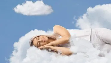 Imagem mostra uma mulher deitada em uma nuvem sonhando