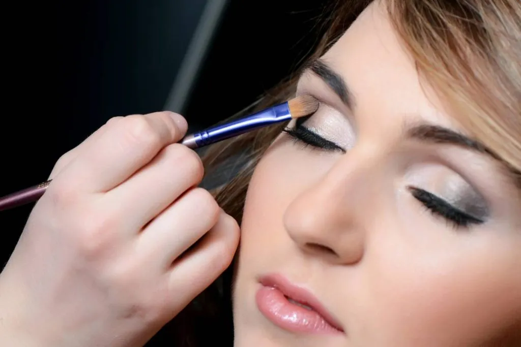 Imagem mostra uma mulher sendo maquiada