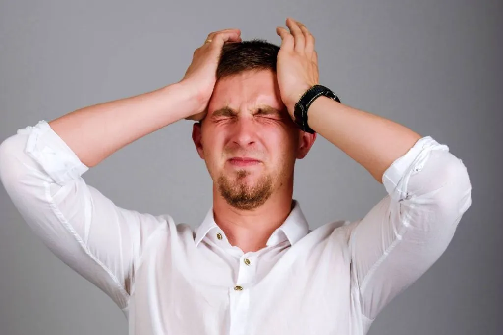 Imagem mostra um homem de camisa branca com as mãos na cabeça, claramente esquecendo de alguma coisa importante.