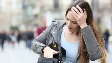 Imagem mostra uma pessoa procurando um documento em uma bolsa.