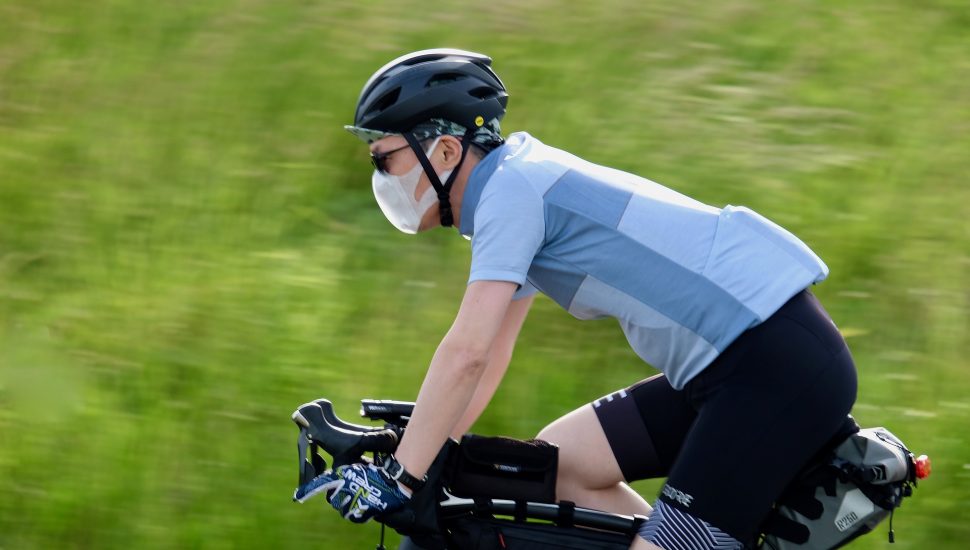 homem de máscara e bicicleta