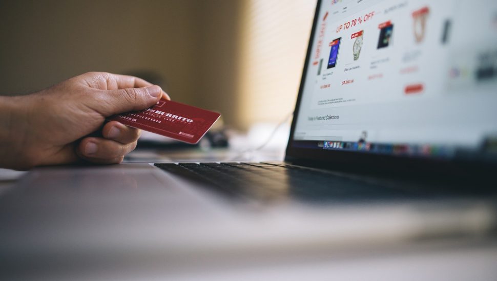 Na imagem, um cartão de crédito e um notebook representando o e-commerce