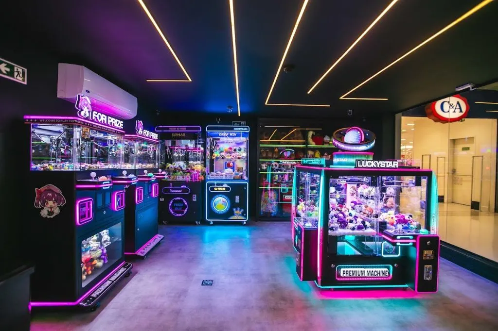 Foto mostra loja com várias maquinas de pescar bichinhos de pelúcia