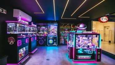 Foto mostra loja com várias maquinas de pescar bichinhos de pelúcia