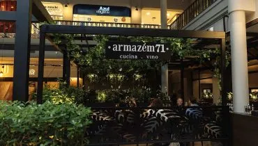 Foto mostra a fachada do Armazem 71, feita por uma placa com o nome do estabelecimento e muitas plantas