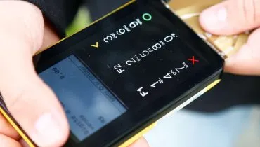 Imagem mostra uma pessoa passando o cartão em uma maquina numa loja.